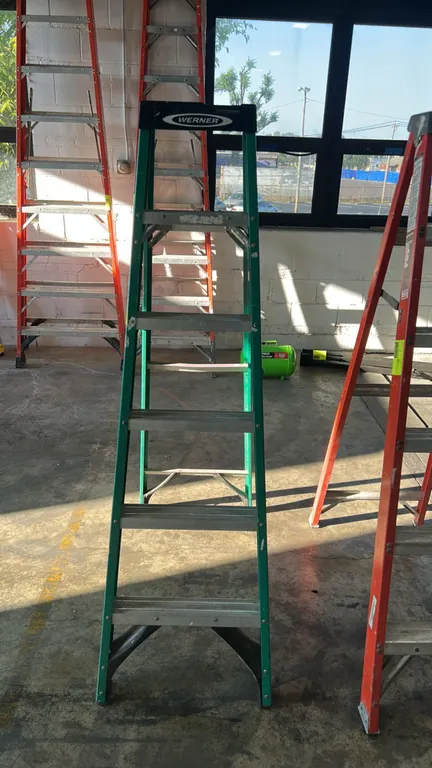 Werner 6' fiberglass stepladder. Features green fiberglass rails, aluminum steps, molded top cap, and external spreader braces. 6'H. Other ladders not