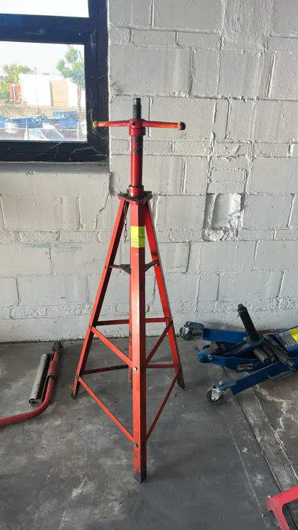 2-ton tripod under-hoist support stand. Features red steel tripod base construction, pin-adjustable column with chained locking pin, and acme threaded