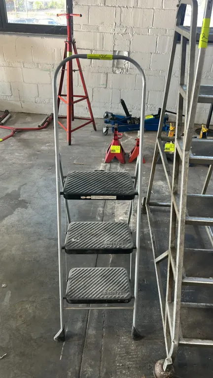 Safety 1st 3-step folding step ladder. Features tubular metal frame with upper handrail, (3) textured slip-resistant plastic steps, and folding mechan
