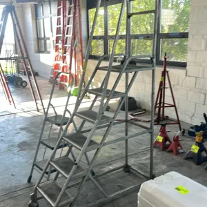 Metal rolling platform ladder. Features a 5-step design including top platform, upper tubular safety handrails, and non-slip tread surfaces. 5'H. Moun