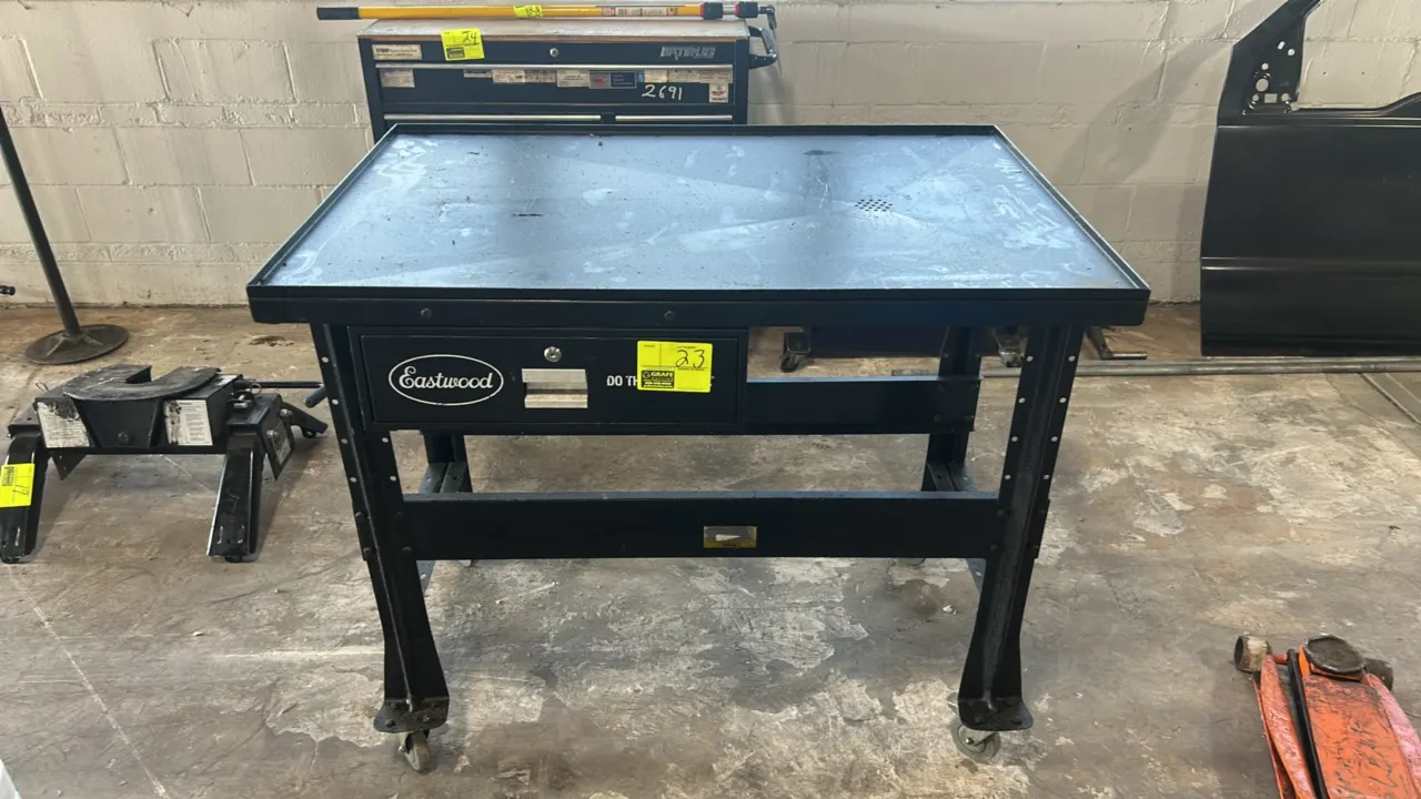 Eastwood portable teardown workbench table. Features steel top with raised perimeter lip and integrated fluid drain grate, single lockable storage dra