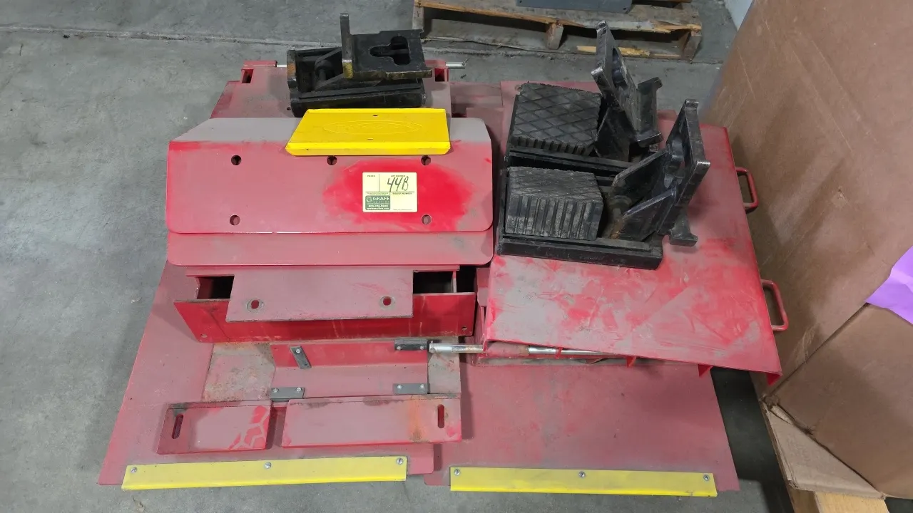 Rotary drive-on automotive lift platform parts and accessories. Includes wheel chocks, ramps, and steel platform components. Finished in red and yello