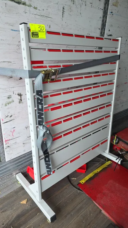 Metal workpiece storage rack. Features multi-tier slotted rail panels with assorted red plastic hanging bins. Free-standing steel frame with leveling