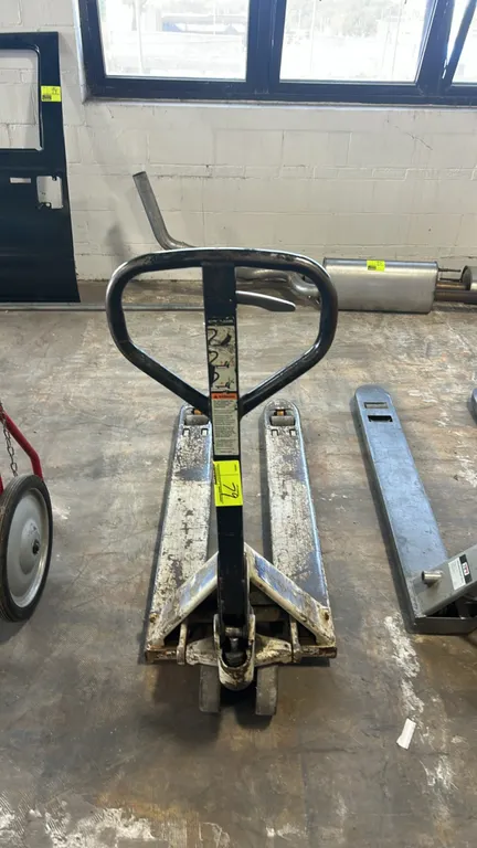 Crown manual narrow fork pallet jack. Features manual hydraulic operation, loop steering handle with 3-position fingertip control lever, dual front st