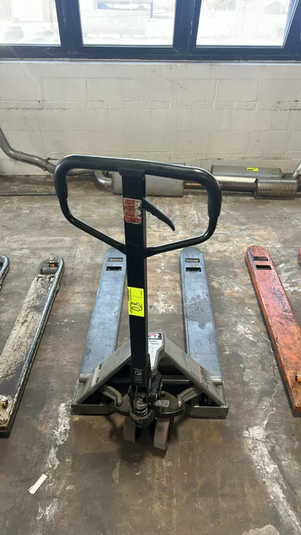 Jet manual pallet jack. Features manual hydraulic pump handle with fingertip control lever, steel forks, dual front steer wheels, and tandem load roll