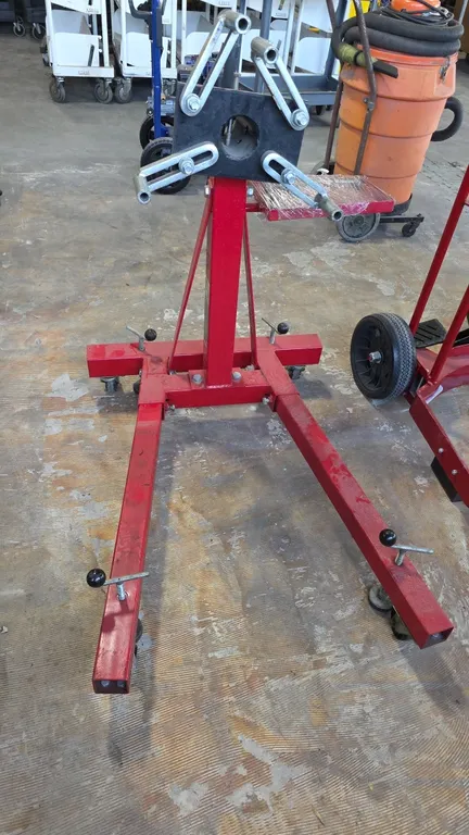 Strongway 47032 1-ton portable engine stand. Features rotating head with locking pin, (4) adjustable mounting arms, and attached tool tray with hardwa
