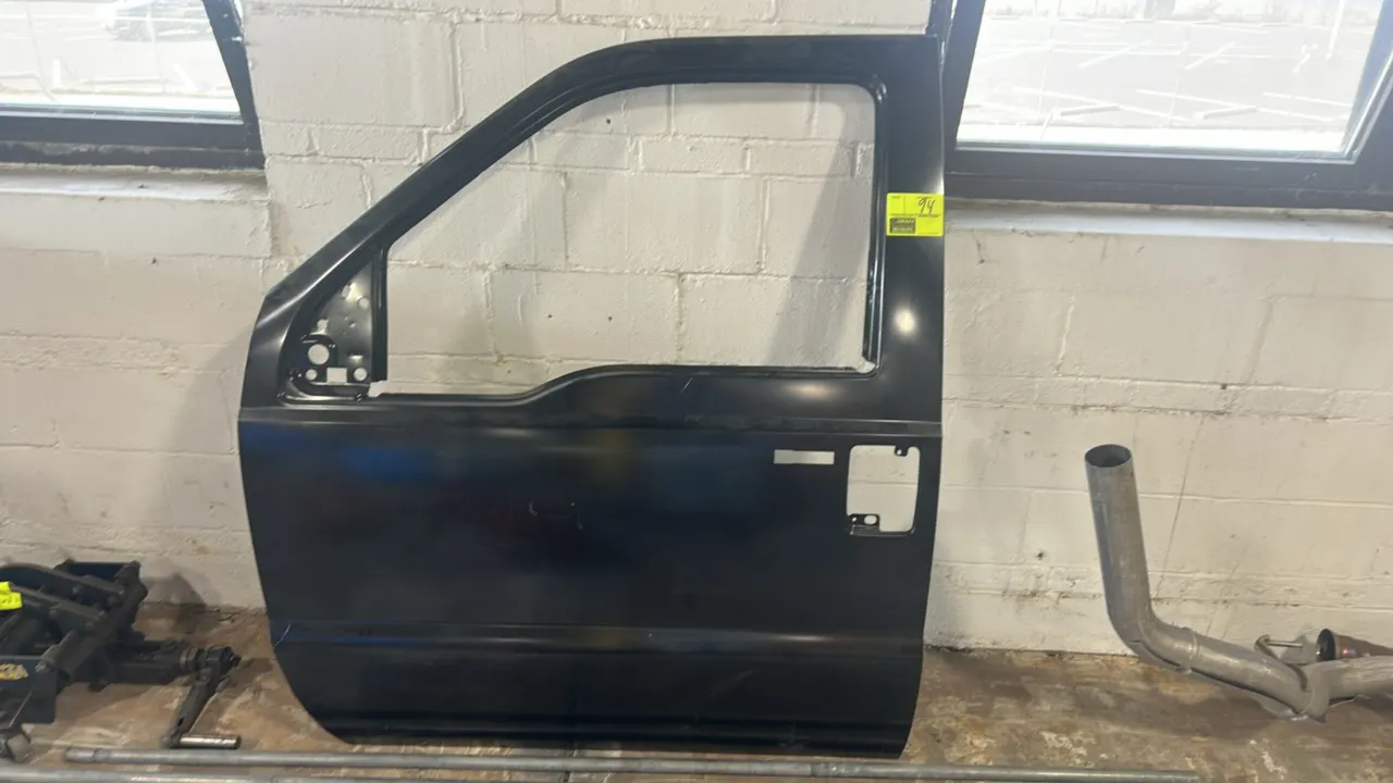Ford front-left (driver side) outer door panel assembly. Features black finish with cutouts for exterior door handle, keyless entry keypad, side mirro