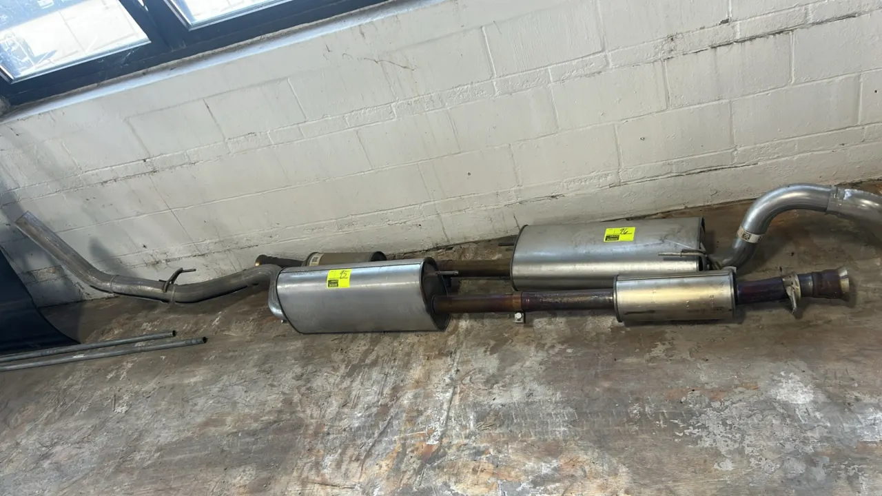 Stainless steel cat-back exhaust system. Includes flanged inlet pipe, inline resonator, muffler, tailpipe section, and integrated exhaust hangers. Not