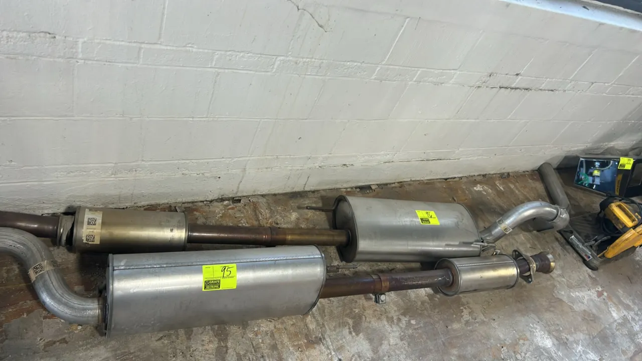 Stainless steel cat-back exhaust system. Features muffler, resonator section, tailpipe, and integrated mounting hangers. Note: Adjacent exhaust system