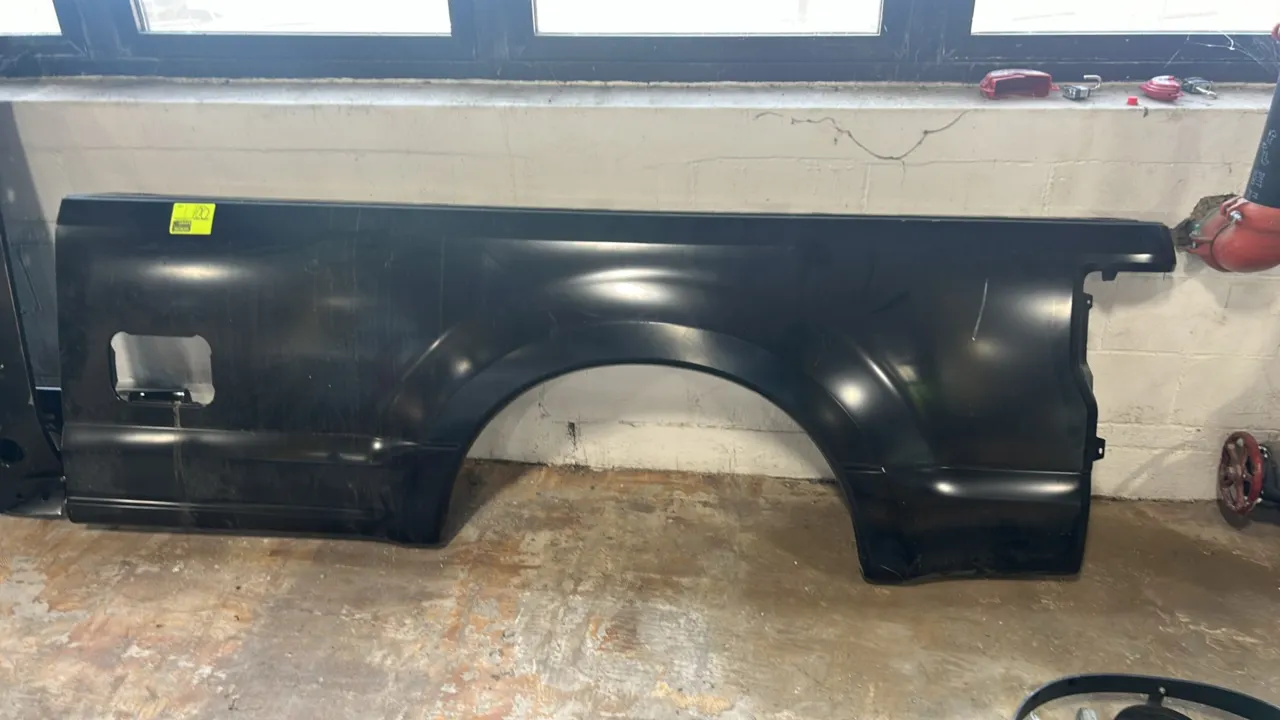 Ford truck bed side panel. Part number: HC3Z-9827841-A. Driver side configuration featuring fuel door opening. Finished in black.