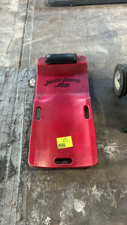 Lisle Jeepers Creeper low-profile poly mechanic's creeper. Features a molded red polyethylene contoured body, padded headrest, and integrated carry ha