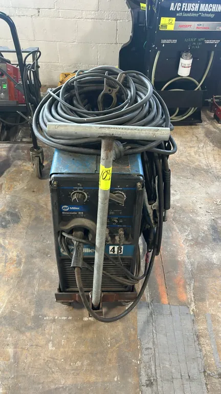 Miller Millermatic 210 wire-feed MIG welding machine. Includes MIG gun, ground clamp lead, and gas regulator. Electrical: 200/230V, 60 Hz, 1-Phase, 31