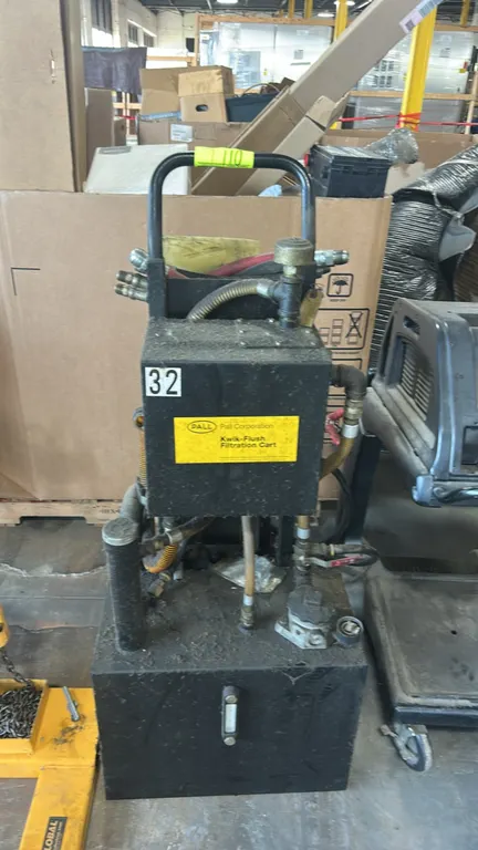 Pall Corporation Kwik-Flush filtration cart. Features integrated fluid reservoir with level sight gauge, diaphragm pump, and hose assembly with quick-