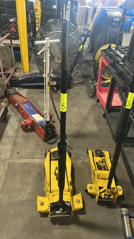 Yellow Jacket hydraulic floor jack. Features manual pump operation, long handle with padded grip, round lift saddle, and front steel wheels. Note: Mis