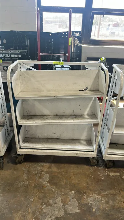 Metal portable multi-tier shelving cart. Features 3 metal shelves with back panels and tubular metal side frames with handles. 32" x 16". Mounted on s