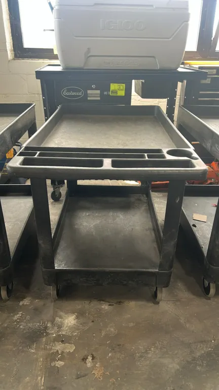 Poly 2-tier utility cart. Features (2) deep basin shelves and integrated push handle with molded tool compartments and cup holder. 44"L. Mounted on ca