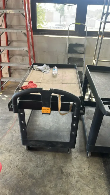 Poly 2-tier utility cart. Features molded push handle with integrated storage compartments and (2) lipped utility shelves. 44"L. Mounted on casters. C