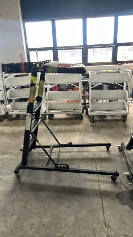 Adjustable topside automotive creeper. Features steel ladder construction, height-adjustable frame, and padded deck. Mounted on swivel casters. Note:
