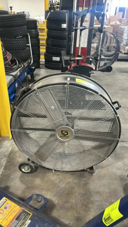 Strongway portable industrial drum fan. Features 4-blade design, metal wire safety grilles, transport handle, and cord wrap. 3' diameter. Mounted on t