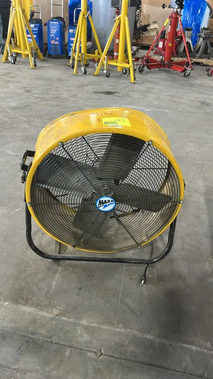 Maxx Air tilting drum fan. Features a yellow metal drum housing, 4-blade assembly, wire safety grilles, carry handle, and adjustable tilt knobs. 24" d