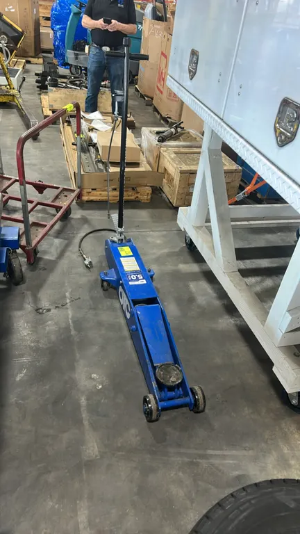 OTC HDJ5P 5-ton air/hydraulic service jack. Features pneumatic operation with attached air hose and valve, foot pump pedal, T-handle with release mech