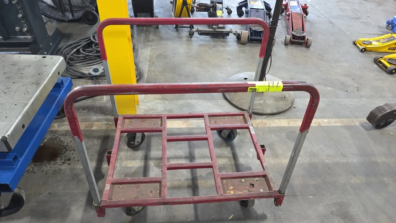 Metal 4-wheel platform cart. Features dual tubular steel push handles and an open steel frame base. 36" x 27.5". Mounted on 4 casters.