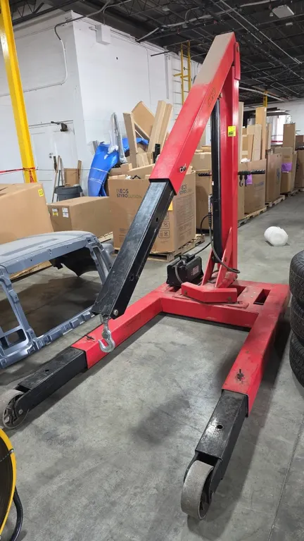Norco 78600B 3-ton air/hydraulic shop crane. Features an air/hydraulic foot pump, multi-position telescoping boom with swivel hook, extendable legs, a