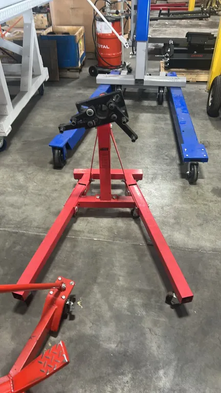 JEGS folding engine stand. Features 360-degree rotating head with adjustable mounting arms and folding legs with locking pins. Mounted on caster wheel