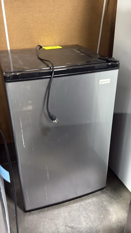 Magic Chef undercounter refrigerator. Features single-door construction with stainless-look finish and black cabinet, top chiller compartment, glass s