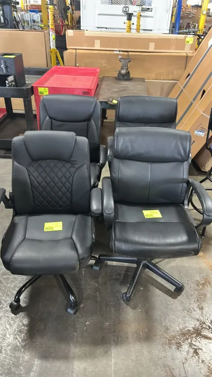 Cushioned office chairs. Features assorted executive styles with black faux leather upholstery, padded armrests, and contoured seats. Mounted on 5-sta
