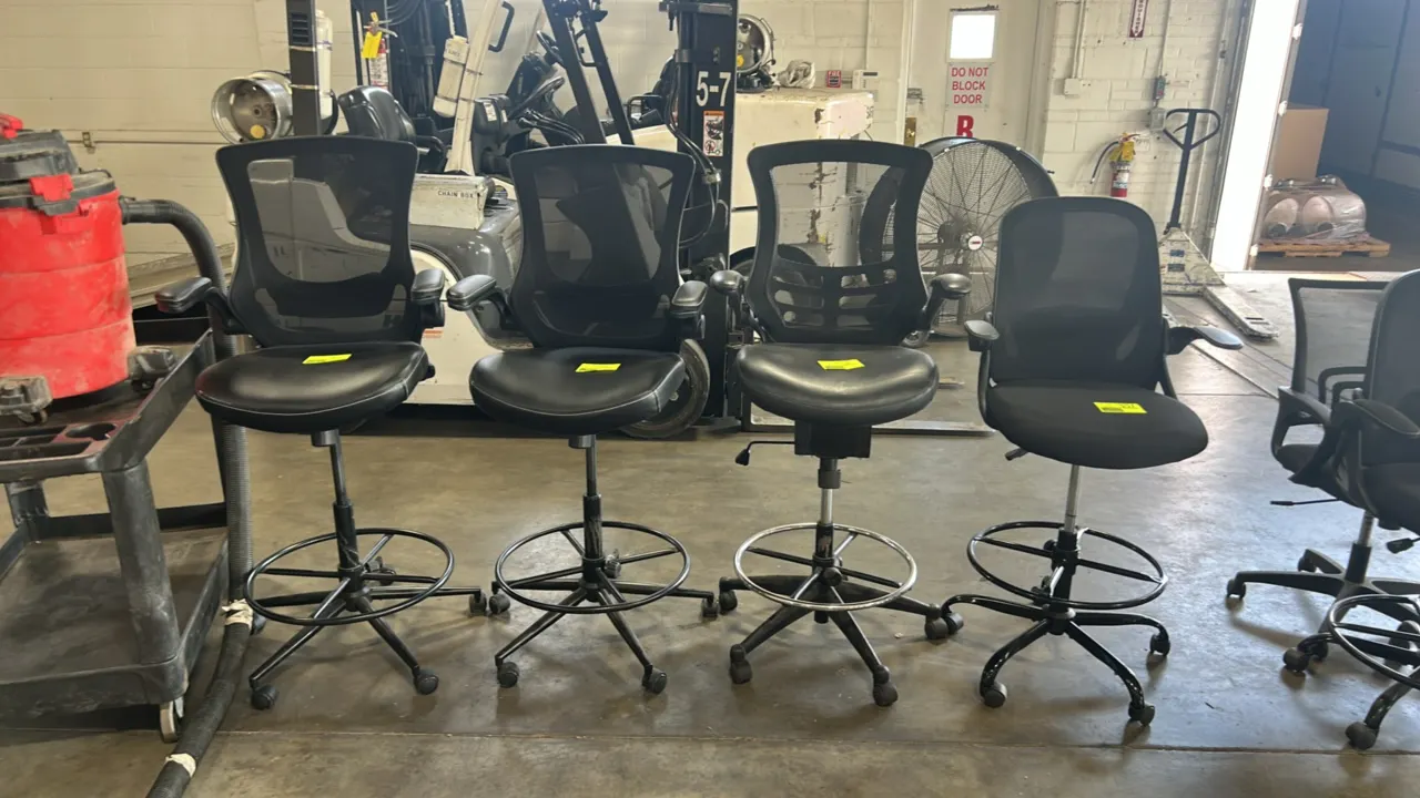 Rolling mesh drafting chairs. Features black mesh backrests, cushioned seats, flip-up armrests, and circular footrest rings. Height adjustable. Mounte