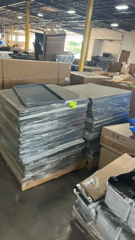 Pallets of industrial metal shelf panels. Features painted steel construction with formed flanges and pre-punched holes for shelf dividers. Includes g