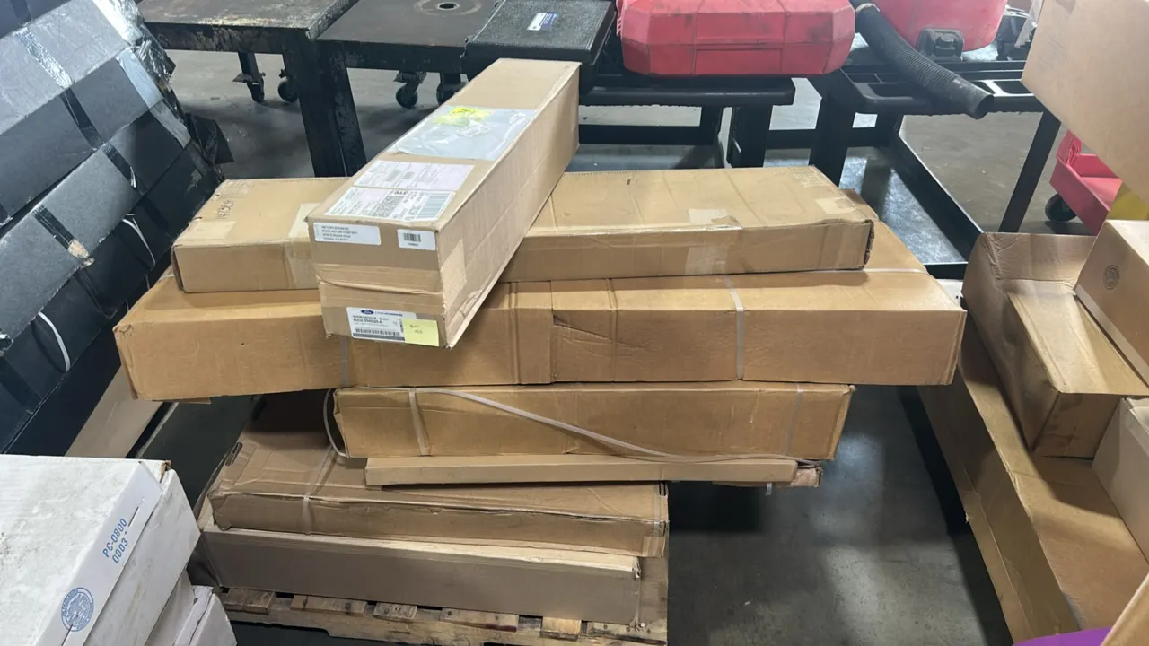 Pallet of genuine Ford and Lincoln OEM automotive parts. Includes Bronco soft spare tire cover (P/N: M2DZ-9945026-A), cargo security shade (P/N: FA1Z-