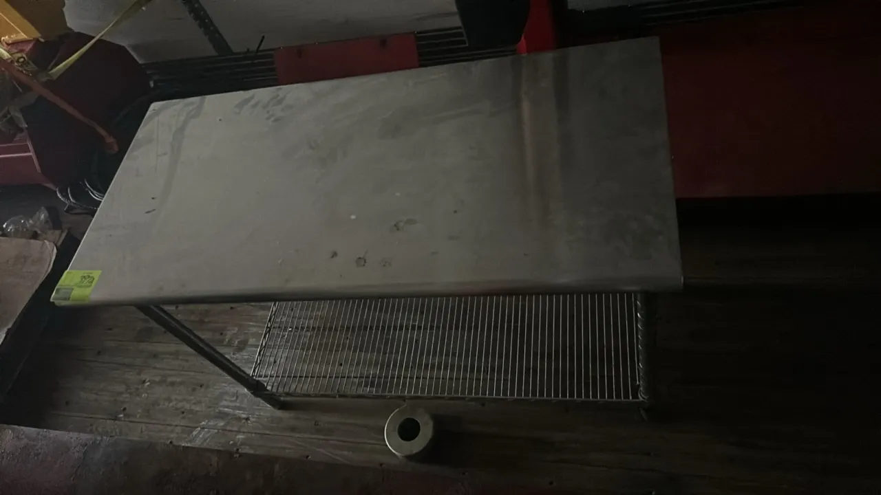 Stainless steel work table. Features a stainless steel work surface and wire undershelf. 4' x 2'. Mounted on tubular legs.