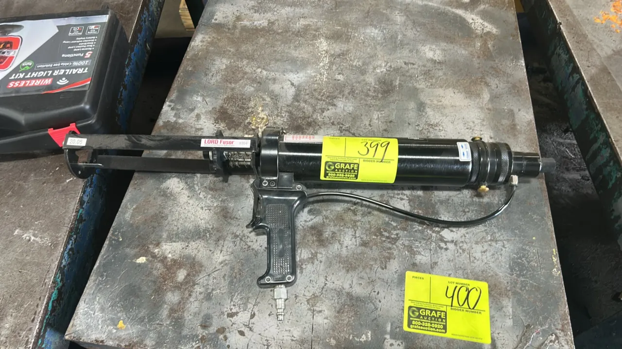 LORD Fusor 304 pneumatic adhesive applicator gun. Features pistol-grip handle with integrated trigger, quick-connect air inlet, forward/reverse select