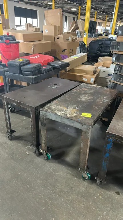 Metal mobile work tables. Features welded steel construction with open base. 4' x 2' each. Mounted on swivel casters.