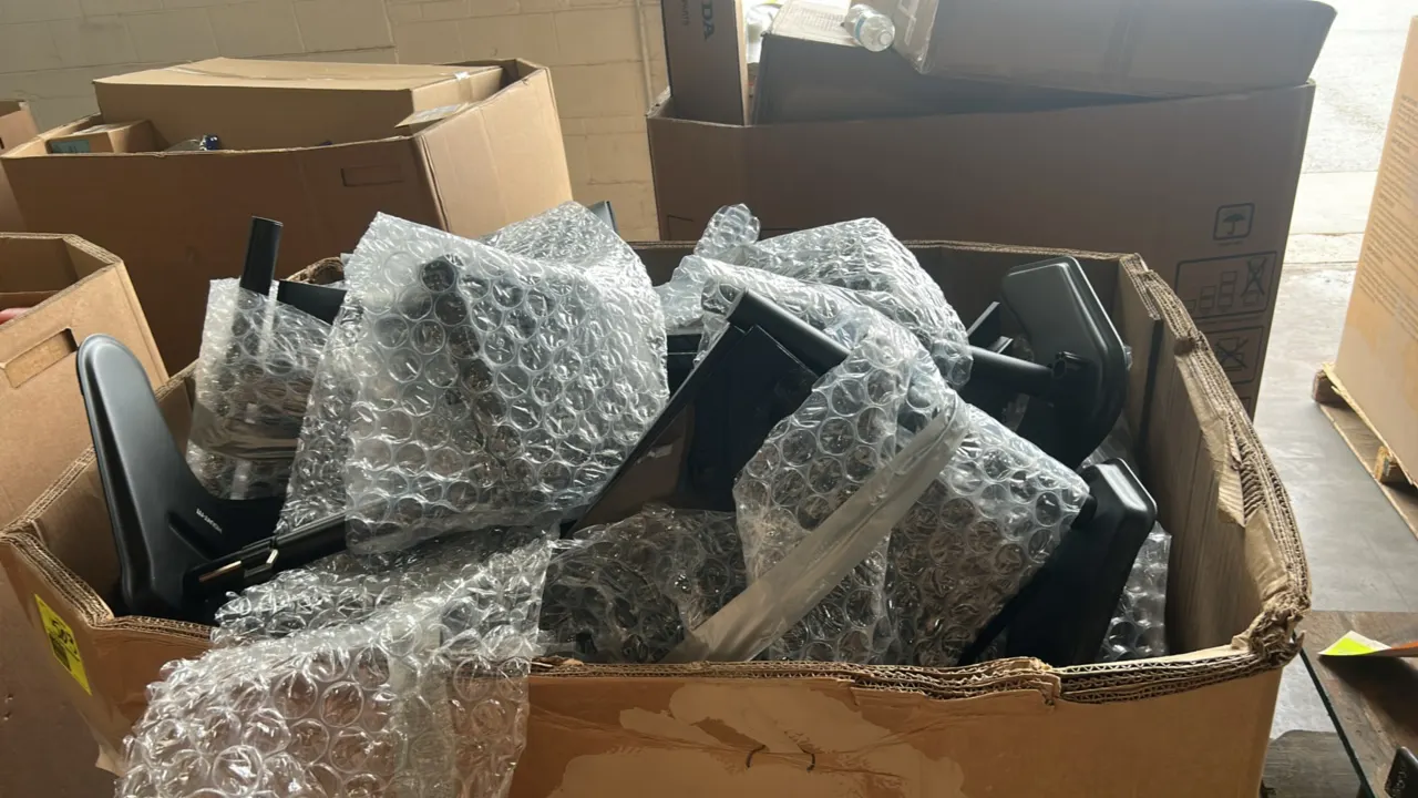 2023 Dell P2222H 21" flat panel monitors in a gaylord container. Bulk lot includes bubble-wrapped units fitted with articulating desk mount arms. Conn