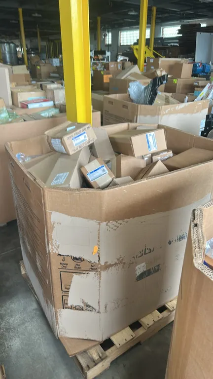 Assorted Ford OEM automotive parts and Gaylord contents. Includes upper sliding door roller assembly (P/N F2UZ-1525028-A), driver side outside door mo