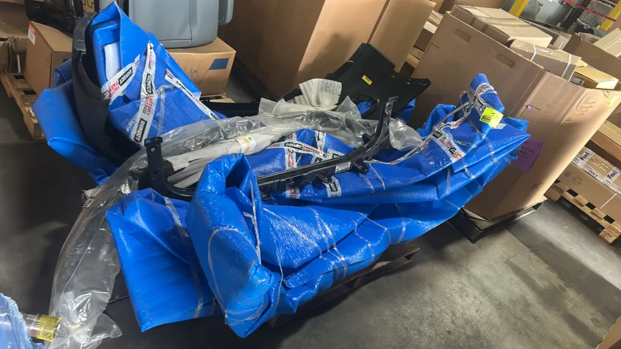Assorted Ford OEM automotive body and support parts. Includes rear bumper lower cover (P/N: FT4Z 17K835 K), front upper radiator support tie bar (P/N: