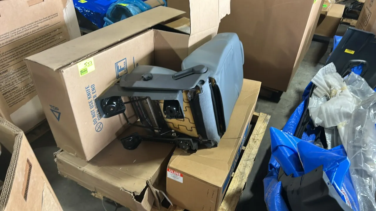 Pallet lot of automotive and commercial goods. Includes National Seating Ensign Lo Pro semi-truck air ride seat (Part: 71123.301) in gray vinyl, Uline
