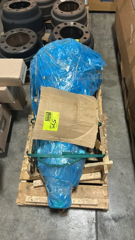 Ford OEM transmission assembly. Unit is sealed in protective blue plastic wrapping and secured with strapping to a wooden pallet. Surrounding inventor
