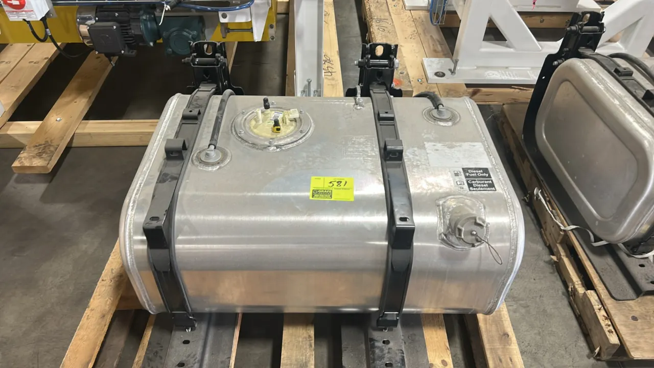 Ford aluminum semi-truck diesel fuel tank. Features filler neck with tethered cap, top fuel sender assembly, and two mounting brackets with retention