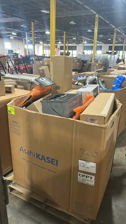 Assorted Ford automotive parts and mixed merchandise lot in a Gaylord container. Includes Ford EGR cooler kit (part number 4C3Z-9P456-AJ), Ford coolan
