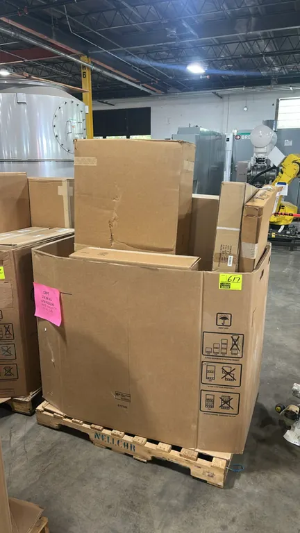 Assorted Ford automotive parts. Features an assortment of boxed automotive components and accessories packaged in a bulk cardboard Gaylord container.