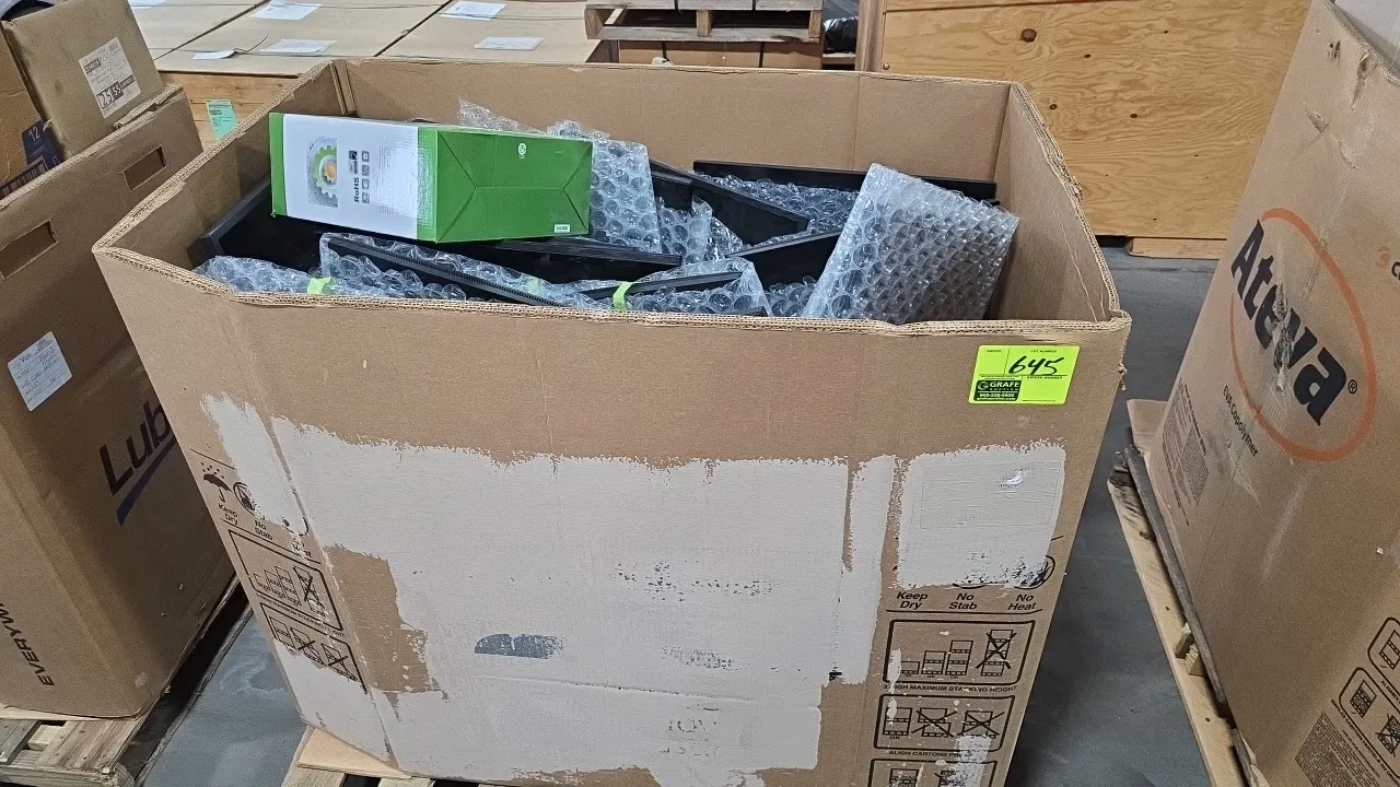 Dell assorted flat panel computer monitors in a gaylord box. Includes visible models E2222HS (Mfg. 2023) and SE2722H (Mfg. 2021), monitor stands, and