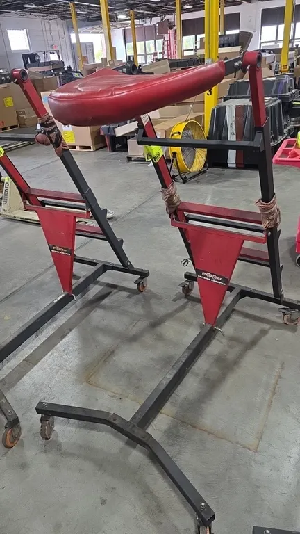 ProGear topside creeper. Features an adjustable height steel frame, red padded vinyl chest support deck, and integrated ladder steps. Mounted on a mob