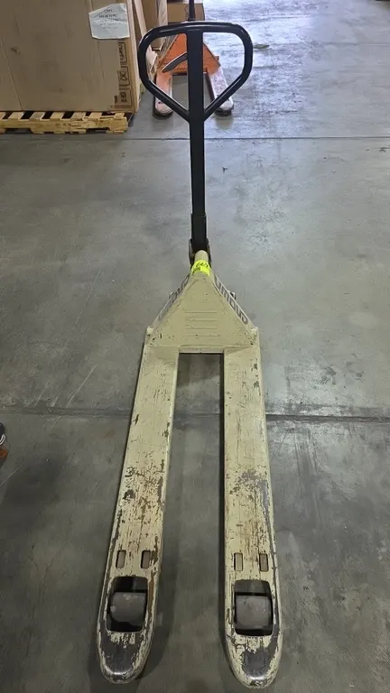 Crown PTH50 20-48 manual narrow pallet jack. Features 5,000 lb capacity, hydraulic pump handle with release lever, and polyurethane wheels. Forks meas