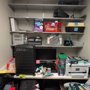 Laminate office workstation suite. Includes 6' laminate desk, 6' laminate 4-tier wall-mounted shelving unit, 4' metal-framed cork board, and 3' wood-f