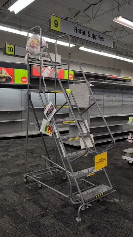 Tri-Arc steel warehouse rolling stock ladder. Features 7 steps with perforated slip-resistant treads, dual handrails, and a top platform with guardrai