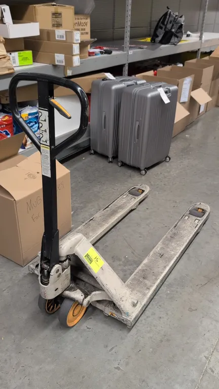 Crown PTH50 27-48 manual pallet jack. Features a 5,000 lb capacity, 3-position hand control lever, dual steer wheels, and entry rollers. S/N: 7-754372